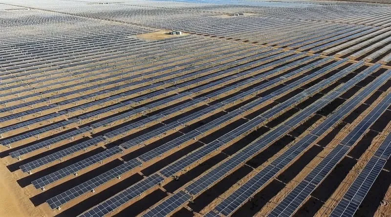 Vista aérea de usina solar fotovoltaica, com longas fileiras de painéis em terreno aberto